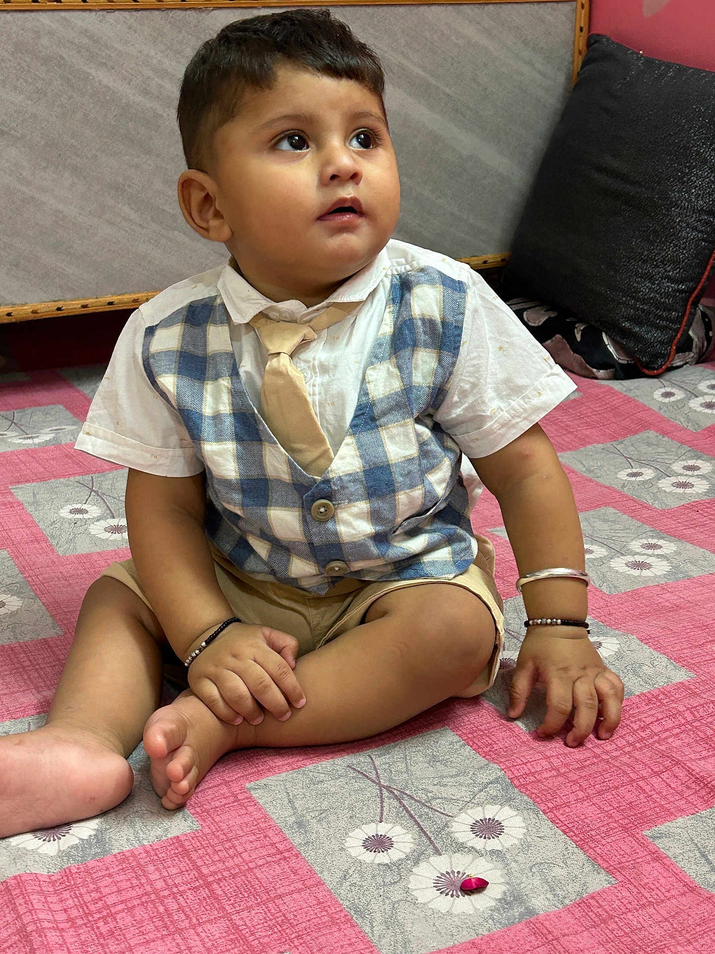 Areeb joined the competition — help win amazing prizes! toddler, child, indoor, bedspread, pink, vest, tie, shorts, bracelet, pillow, sitting, curious, hands, feet, floor, fabric, pattern, portrait, cute, young