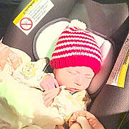 Paisley joined the competition — help win amazing prizes! newborn, baby, sleeping, car_seat, blanket, knit_hat, red_hat, striped_hat, infant, child, warning_label, cozy, wrapped, indoor, peaceful, clothing, bottle, soft, cute, resting