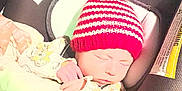 Paisley joined the competition — help win amazing prizes! baby, blanket, bottle, car_seat, child, clothing, cozy, cute, indoor, infant, knit_hat, newborn, peaceful, red_hat, resting, sleeping, soft, striped_hat, warning_label, wrapped
