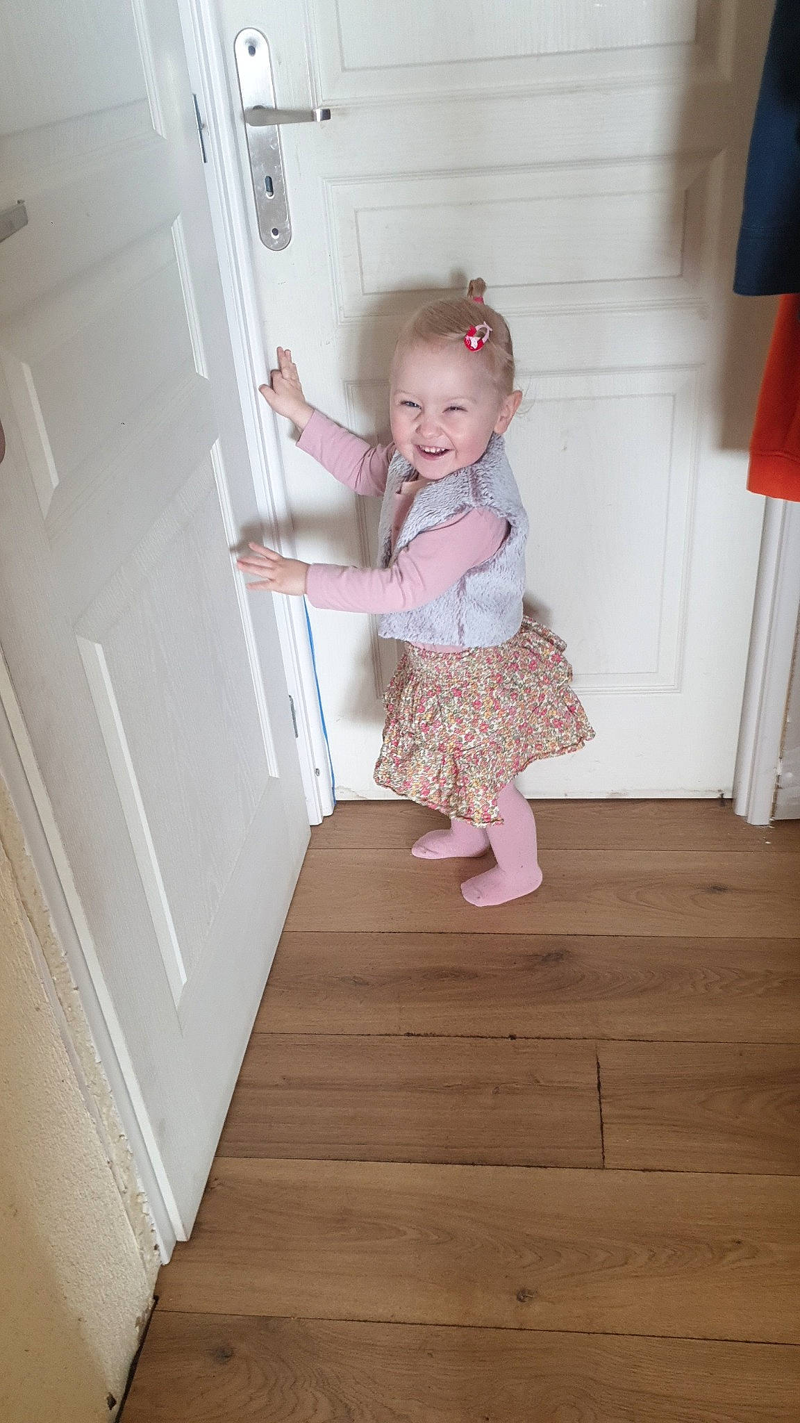 Chloé a rejoint le concours — aidez-le/la à gagner de superbes lots ! baby_toddler_clothing, child, door, dress, floor, flooring, hardwood, house, joy, laminate_flooring, leg, magenta, pattern, person, pink, sleeve, smile, stairs, toddler, varnish