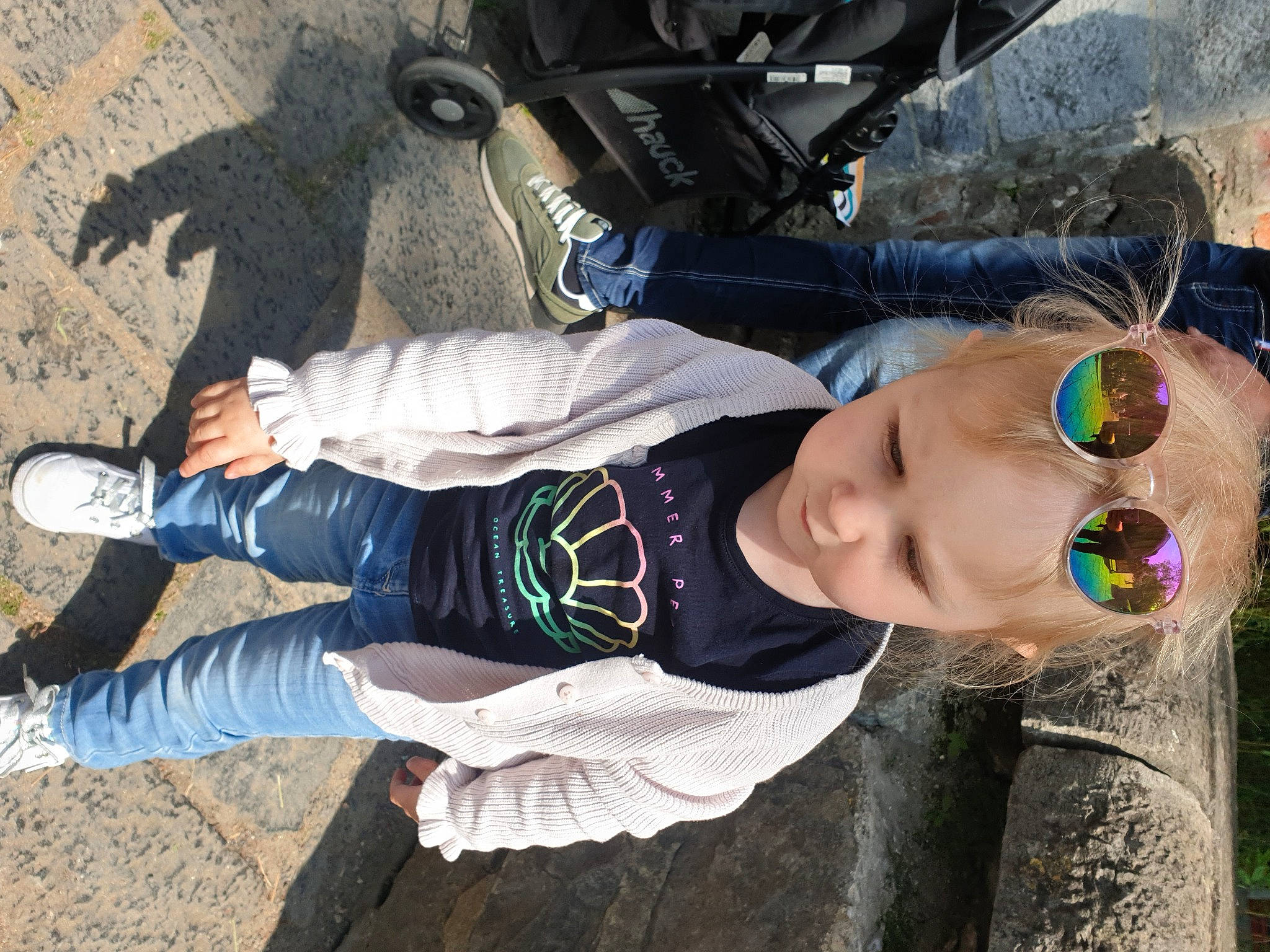 Chloé participe au concours pour gagner de l'argent avec cette photo : black, child, cool, eyewear, fun, glasses, goggles, grass, human_leg, person, personal_protective_equipment, recreation, sitting, sock, soil, sunglasses, toddler, tree, walking_shoe, white