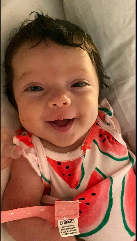 Liliana is registered to the contest to win money with this photo: baby, baby_toddler_clothing, cheek, child, dress, eye, eyelash, face, happy, head, iris, joy, lip, mouth, neck, nose, person, pink, skin, sleeve