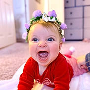 Coralie joined the competition — help win amazing prizes! baby, child, smiling, laughing, flower_crown, red_clothing, blue_eyes, blanket, indoor, carpet, happy, cute, toddler, portrait, headwear, person, infant, cheerful, young_child, home