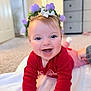 Coralie is registered to the contest to win money with this photo: baby, child, smiling, crawling, flower_crown, red_clothing, blanket, indoors, carpet, happy, face, cute, infant, cheerful, portrait, hands, eyes, tooth, soft_light, person