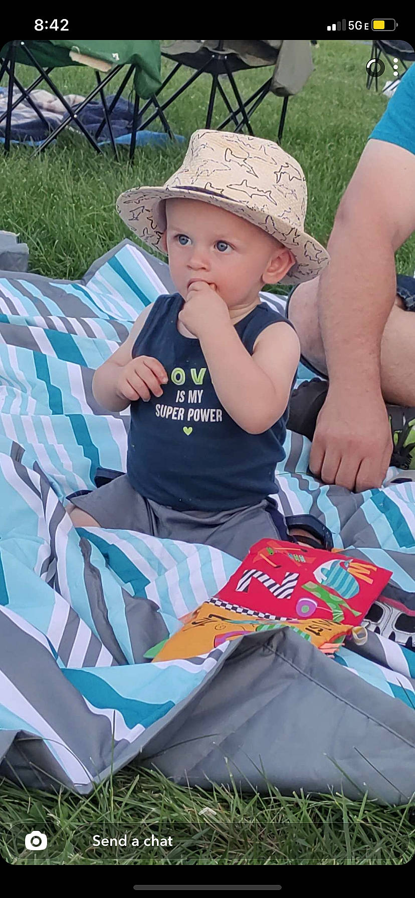 Jaxxon is registered to the contest to win money with this photo: baby, baby_toddler_clothing, blue, cap, child, event, fashion_accessory, fun, grass, green, happy, hat, headwear, leisure, outdoor_recreation, person, product, recreation, sitting, sun_hat