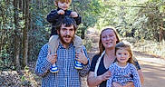 Adalyn is registered to the contest to win money with this photo: casual_clothing, child, child_on_shoulders, daytime, family, forest, happy, holding_child, man, nature, outdoor, parent, path, people, portrait, smiling, sunlight, trees, walking, woman
