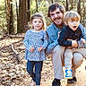 child, children, man, forest, trees, outdoor, nature, smile, happy, boy, girl, family, casual_clothing, walking_path, daylight, leaves, pants, shirt, sneakers, beard
