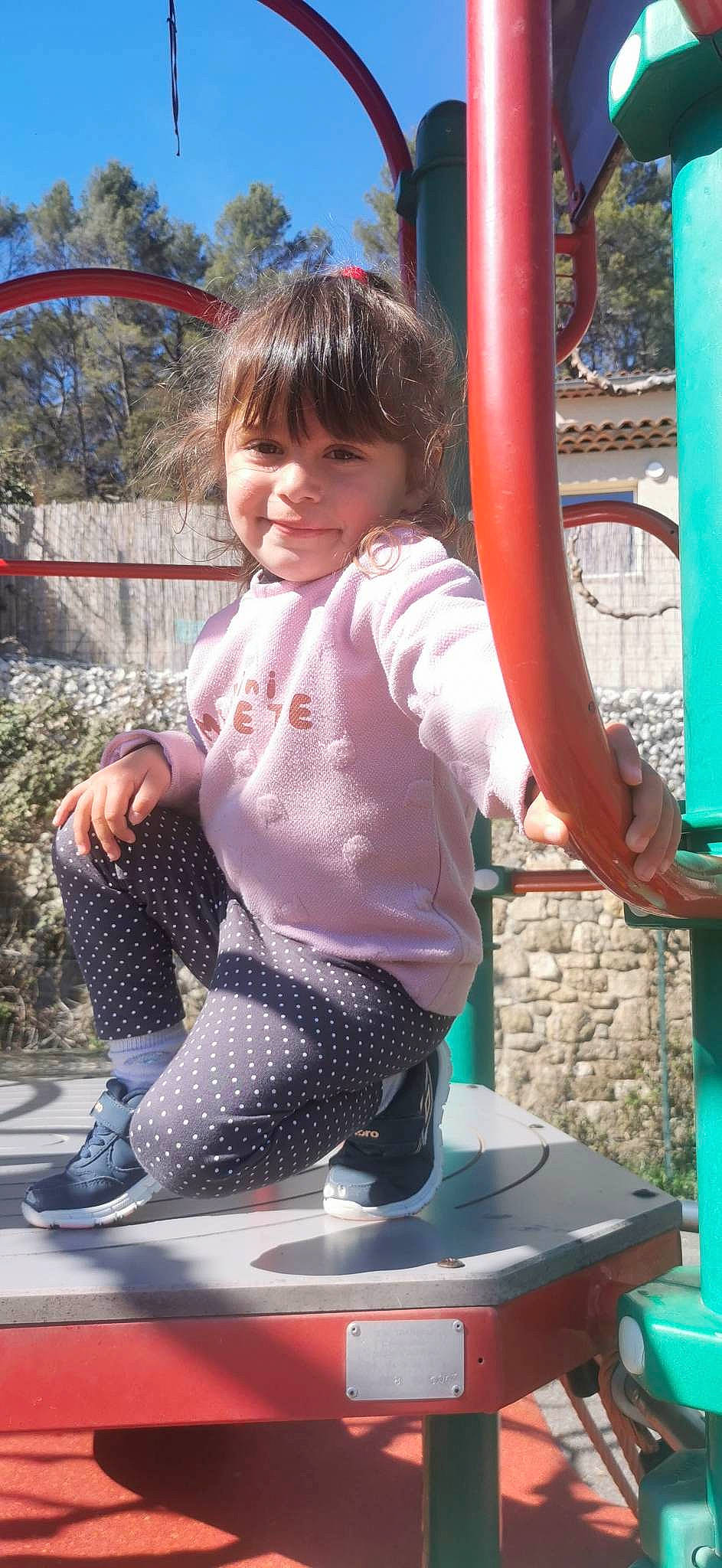 Athéna participe au concours pour gagner de l'argent avec cette photo : baby_toddler_clothing, balance, blue, child, city, fun, happy, joy, leisure, magenta, pattern, person, pink, plant, play, playground, public_space, recreation, sitting, smile