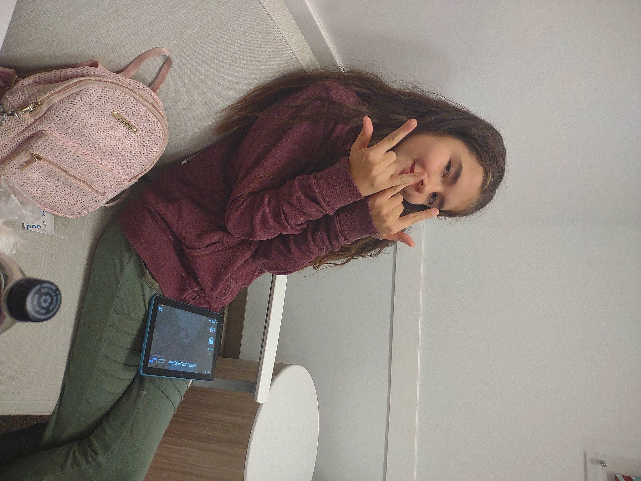 Alana is registered to the contest to win money with this photo: audio_equipment, bag, comfort, communication_device, elbow, electronic_device, fashion_accessory, gadget, gesture, home_appliance, human_leg, knee, leg, luggage_and_bags, magenta, person, room, sitting, smile, thigh