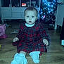 Vaiva is registered to the contest to win money with this photo: baby, cabinet, child, christmas_tree, cute, festive, floor, furniture, holiday, home, indoor, lights, plaid, portrait, red_dress, sitting, socks, toddler, toys, wooden_floor