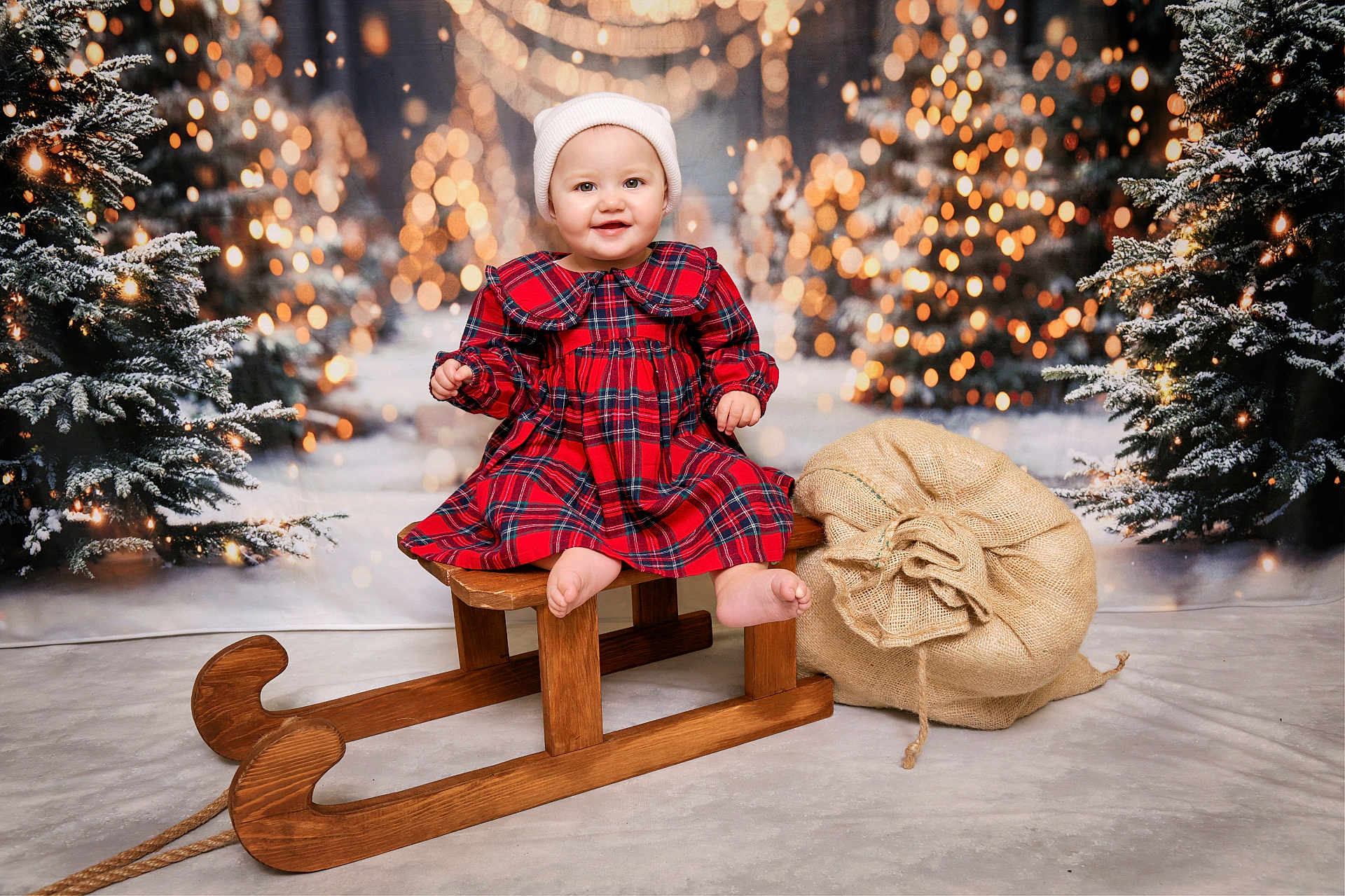 Vaiva is registered to the contest to win money with this photo: baby, child, sled, christmas, holiday, festive, plaid_dress, hat, smile, winter, snow, tree, lights, burlap_sack, wood, indoor, portrait, cute, happy, seasonal