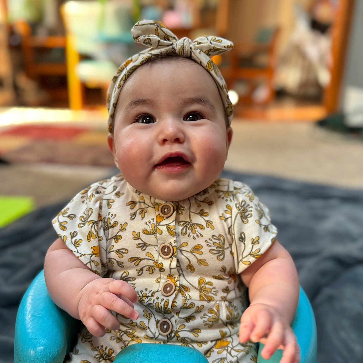 Keirra is registered to the contest to win money with this photo: accessories, baby, bodypart, clothing, couch, dress, face, finger, hand, happy, hat, head, headband, indoors, newborn, person, photography, portrait, sitting, smile