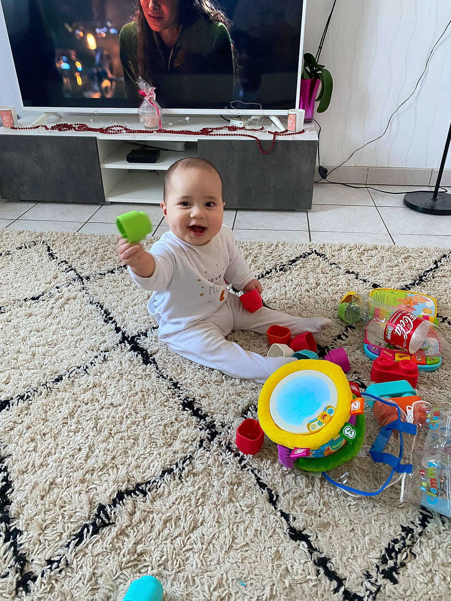 Temoe a rejoint le concours — aidez-le/la à gagner de superbes lots ! baby, baby_playing_with_toys, baby_toddler_clothing, child, design, floor, flooring, fun, happy, leisure, people, person, photograph, play, product, smile, snapshot, television, television_set, toddler