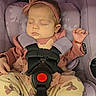 baby, bow, bracelet, car_seat, child, closed_eyes, fashion_accessories, floral_pattern, harness, headband, indoors, infant, nap, padded_seat, peaceful, pink_clothing, portrait, resting, seat_buckle, sleeping