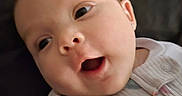 Adalyn joined the competition — help win amazing prizes! baby, infant, child, smiling, happy, face, portrait, close_up, indoor, knitted_clothing, sweater, blanket, cushion, seated, lying_down, head, eyes, open_mouth, earring, cozy