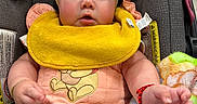 Sahily joined the competition — help win amazing prizes! baby, child, car_seat, yellow_bib, headband, toy, pink_clothing, person, infant, cute, indoor, seatbelt, colorful, accessory, plush_blanket, arm, hand, face, expression, clothing
