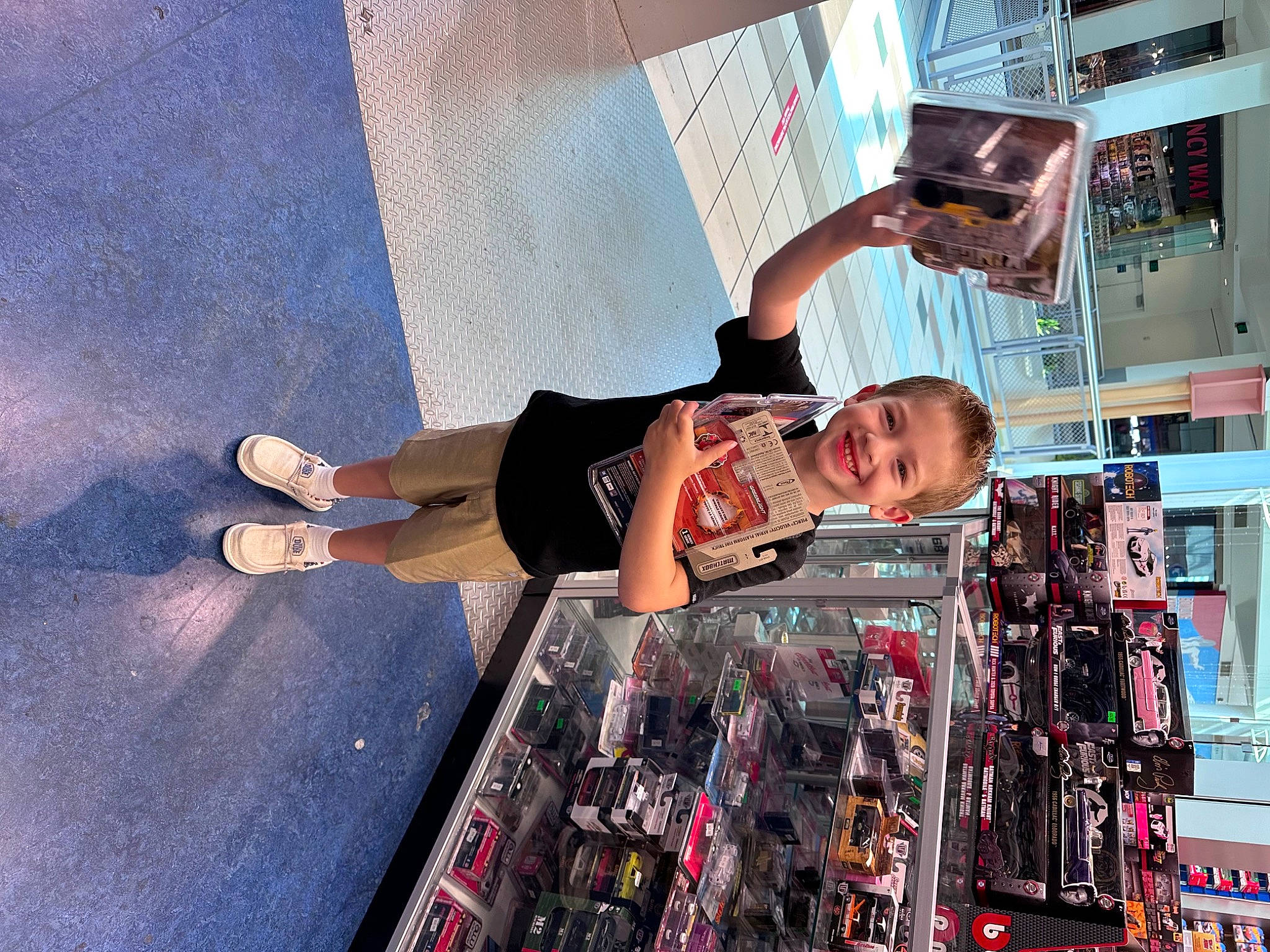 Gunner is registered to the contest to win money with this photo: building, engineering, eyewear, fun, human_leg, joy, knee, leisure, machine, person, recreation, shorts, sportswear, standing, street, t_shirt, thigh