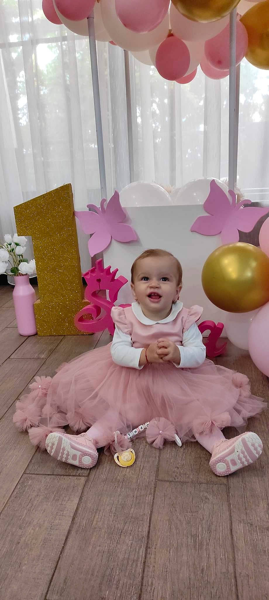 Sophia Maria a rejoint le concours — aidez-le/la à gagner de superbes lots ! baby, baby_toddler_clothing, balloon, child, decoration, event, flooring, happy, magenta, party_supply, person, petal, pink, plant, purple, room, sitting, smile, textile, toddler