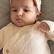 Laya Bailich participe au concours pour gagner de l'argent avec cette photo : baby, infant, headband, pink, cute, clothing, pout, hand, lying_down, quilted, fabric, closeup, skin, face, newborn, young_child, apparel, portrait, indoors, child