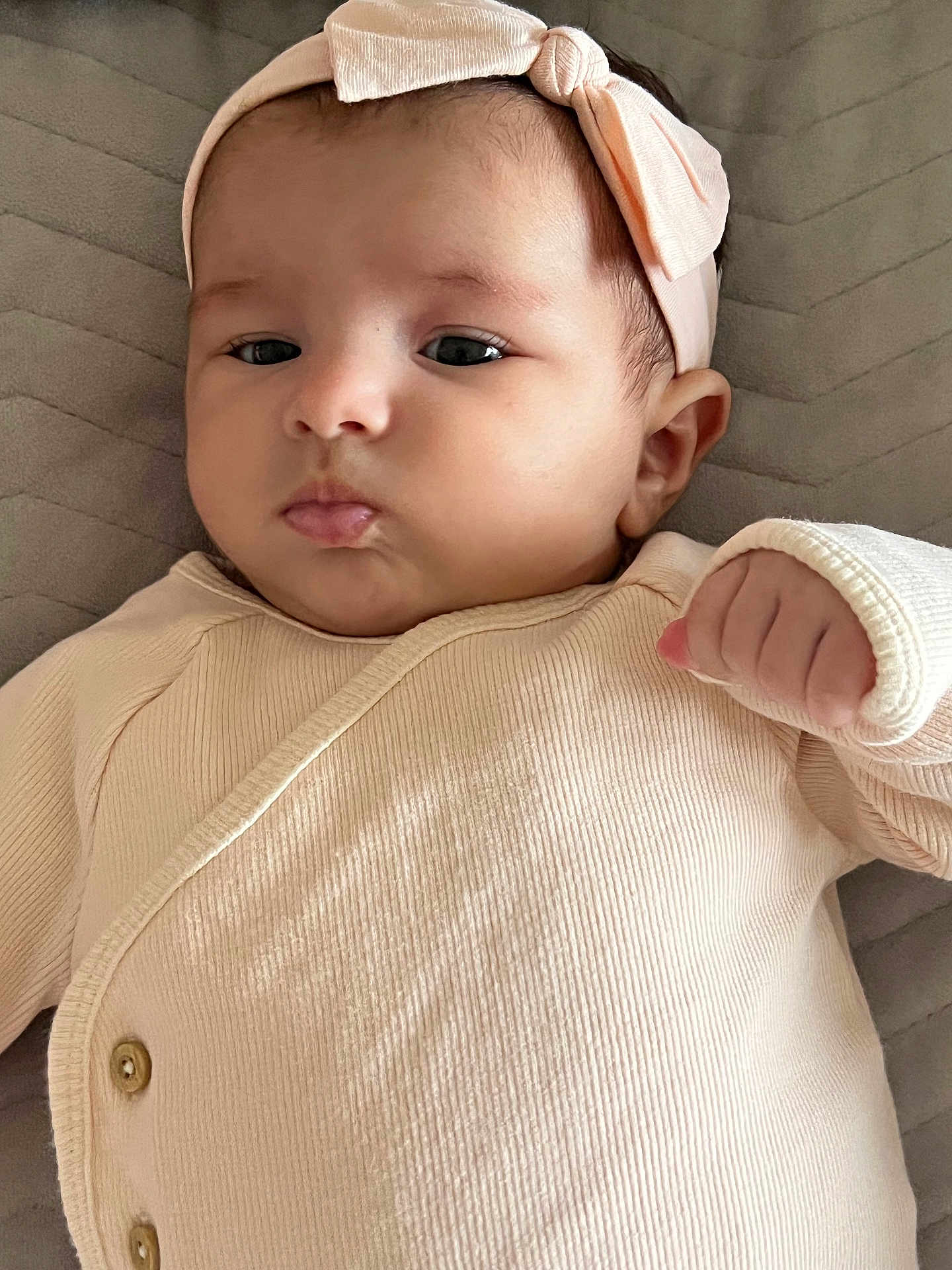 Laya Bailich participe au concours pour gagner de l'argent avec cette photo : baby, infant, headband, pink, cute, clothing, pout, hand, lying_down, quilted, fabric, closeup, skin, face, newborn, young_child, apparel, portrait, indoors, child