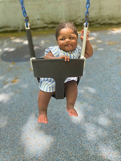 Aniyah is registered to the contest to win money with this photo: baby, baby_toddler_clothing, child, city, electric_blue, face, fun, grass, happy, leisure, outdoor_play_equipment, person, play, playground, public_space, recreation, smile, swing, t_shirt, toddler