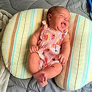 Zorie joined the competition — help win amazing prizes! baby, infant, smiling, laughing, romper, striped_cushion, bedspread, blanket, happy, cute, child, skin, head, feet, arms, clothing, indoors, resting, person, cozy