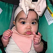 Anahi joined the competition — help win amazing prizes! baby, bib, bow, car_seat, child, close_up, clothing, cute, expression, face, green, hands, headband, indoors, infant, person, pink, portrait, straps, wide_eyes