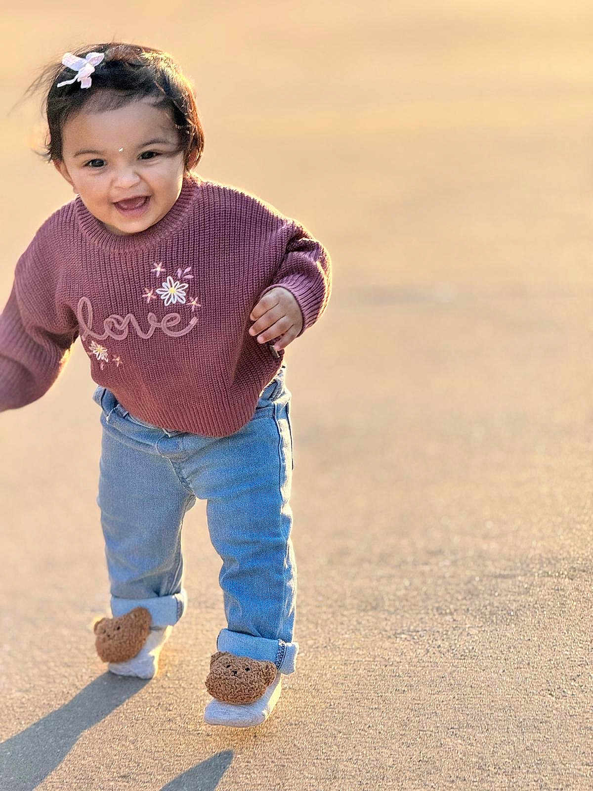 Kiannsha joined the competition — help win amazing prizes! toddler, child, smiling, walking, sweater, love, jeans, footwear, bear_slippers, outdoor, sunlight, shadow, happy, cute, person, clothing, hair_bow, face, young_child, daylight