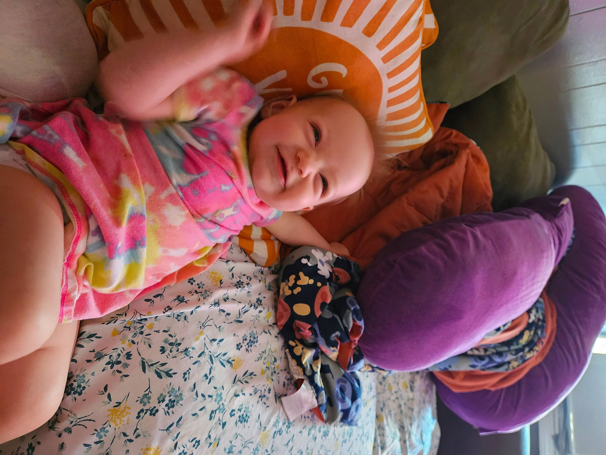 Daisy is registered to the contest to win money with this photo: arm, baby, baby_toddler_clothing, child, comfort, flooring, fun, hand, happy, nose, pattern, person, pink, play, purple, sitting, skin, textile, toddler, tree