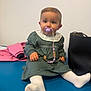Eva a rejoint le concours — aidez-le/la à gagner de superbes lots ! baby, beaded_pacifier_clip, big_eyes, blue_table, child, chubby_cheeks, cute, green_dress, handbag, hands, indoor, lace_collar, pacifier, pink_jacket, portrait, sitting, tabletop, toy, white_socks, white_wall