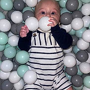 Teddy joined the competition — help win amazing prizes! baby, child, ball_pit, plastic_balls, striped_clothing, romper, indoor, play, cute, infant, hand, face, eyes, legs, toy, colorful, soft_lighting, casual, smiling, fun