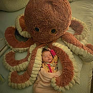Devyn is registered to the contest to win money with this photo: baby, bed, blanket, close_up, cozy, cuddling, face, indoors, infant, nursery, octopus, pajamas, peaceful, photography, plush_toy, portrait, sleeping, soft_toy, stuffed_animal, tentacles