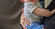 Zarian is registered to the contest to win money with this photo: baby, child, smiling, person, tattoo, spiderweb, knee, hand, clothing, shorts, tshirt, indoor, curtain, window, night, adult, holding, skin, portrait, happy