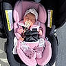 Zoe is registered to the contest to win money with this photo: baby, newborn, sleeping, car_seat, infant, pacifier, headband, pink, floral, mittens, blanket, harness, vehicle, outdoor, sunlight, portrait, face, child, cozy, safety_seat