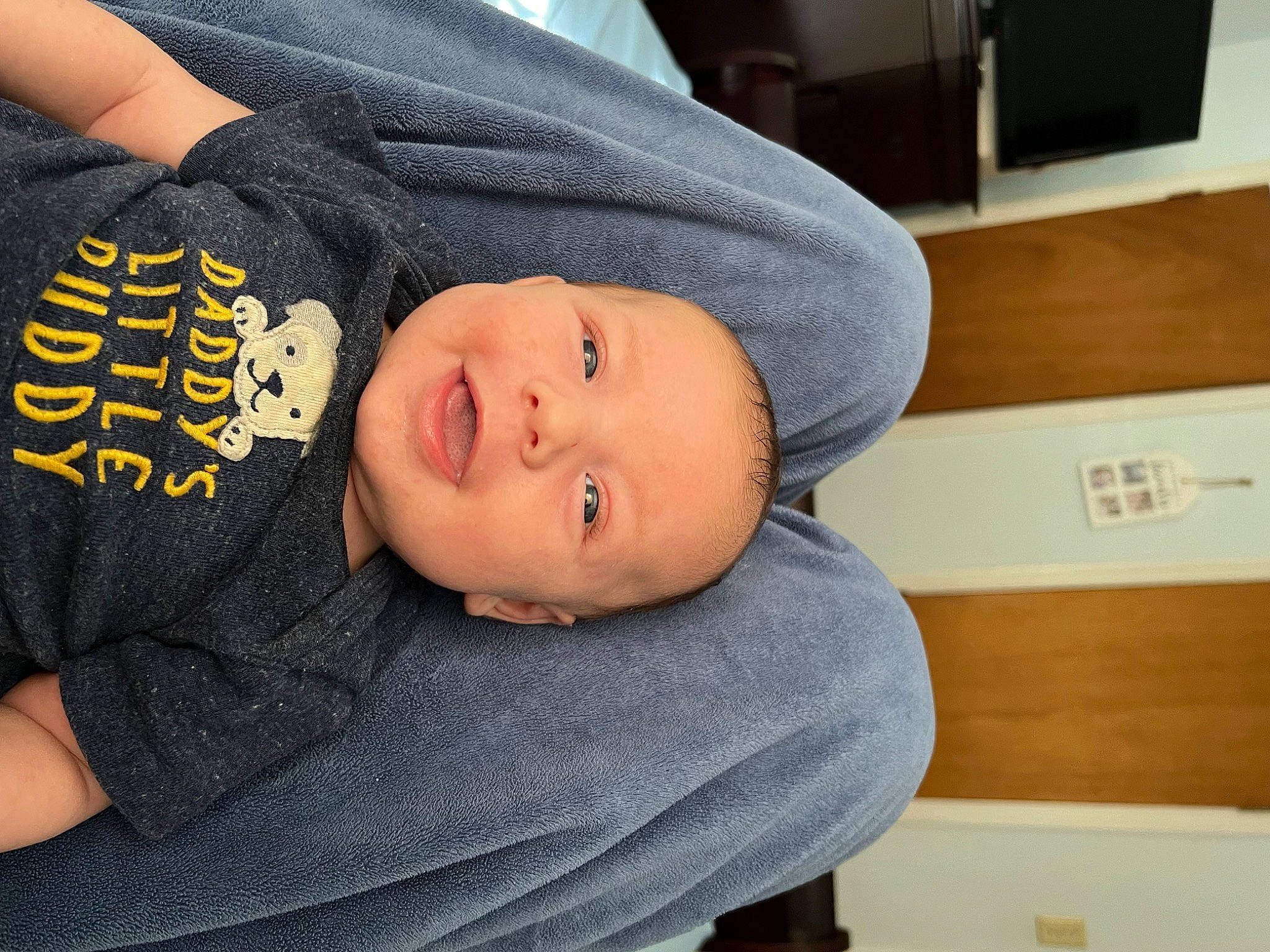 Kasen is registered to the contest to win money with this photo: baby, baby_toddler_clothing, cabinetry, child, comfort, elbow, hat, home_appliance, kitchen_appliance, mouth, person, room, sleeve, smile, t_shirt, television, toddler