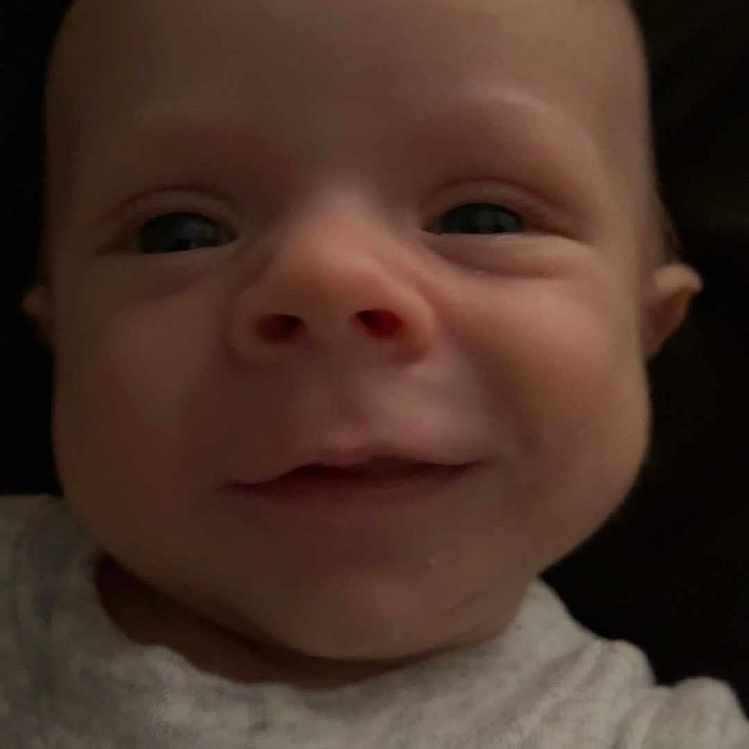 Sawyer is registered to the contest to win money with this photo: apparel, baby, child, closeup, clothing, cute, expression, fabric, face, head, human, indoors, infant, person, portrait, skin, sleeve, smile, soft_light, young