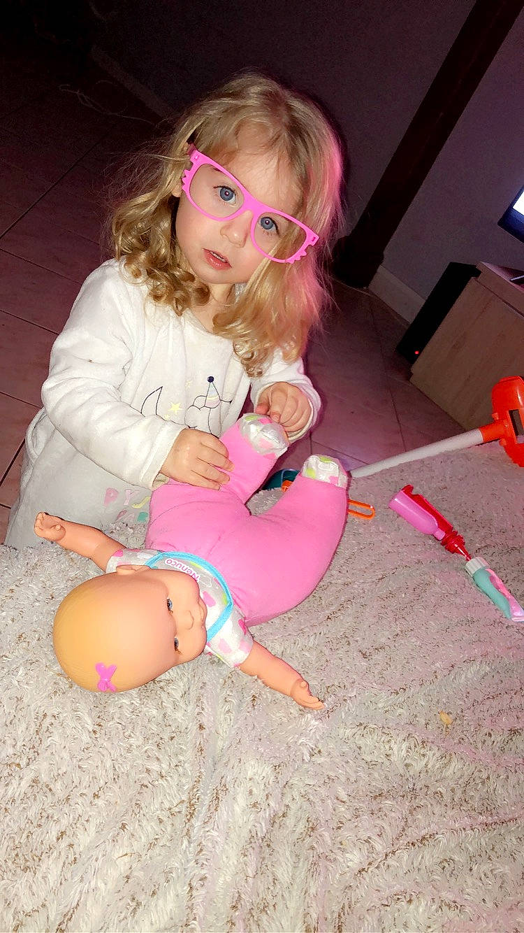 Azélie participe au concours pour gagner de l'argent avec cette photo : abdomen, child, eyewear, facial_expression, finger, foot, fun, hairstyle, human_body, human_leg, knee, lap, navel, person, pink, sitting, skin, stomach, thigh, toddler