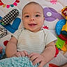 baby, baby_playing, child, close_up, colorful, eyes, face, fuzzy_toy, happy, indoors, infant, lying_down, nursery, onesie, photography, play_mat, portrait, smiling, stuffed_animal, toys