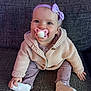 baby, cardigan, child, clothing, couch, cute, footwear, happy, headband, indoor, infant, knitwear, pacifier, person, portrait, purple, sitting, smiling, sock, young_child