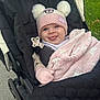 Harley Rose is registered to the contest to win money with this photo: baby, child, stroller, hat, blanket, pink, outdoor, grass, cute, playful, mittens, smiling, face, person, winter_clothing, warm, infant, happy, portrait, cozy