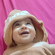 Ramy participe au concours pour gagner de l'argent avec cette photo : baby, smiling, towel, hood, happy, child, infant, face, skin, pink_background, blanket, closeup, portrait, cute, young, expression, lying_down, soft_texture, indoors, warm