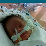 River is registered to the contest to win money with this photo: newborn, baby, hospital, incubator, medical_tubes, blanket, sleeping, face, infant, healthcare, care, patient, child, cute, resting, pediatric, nursery, soft, wrapped, peaceful