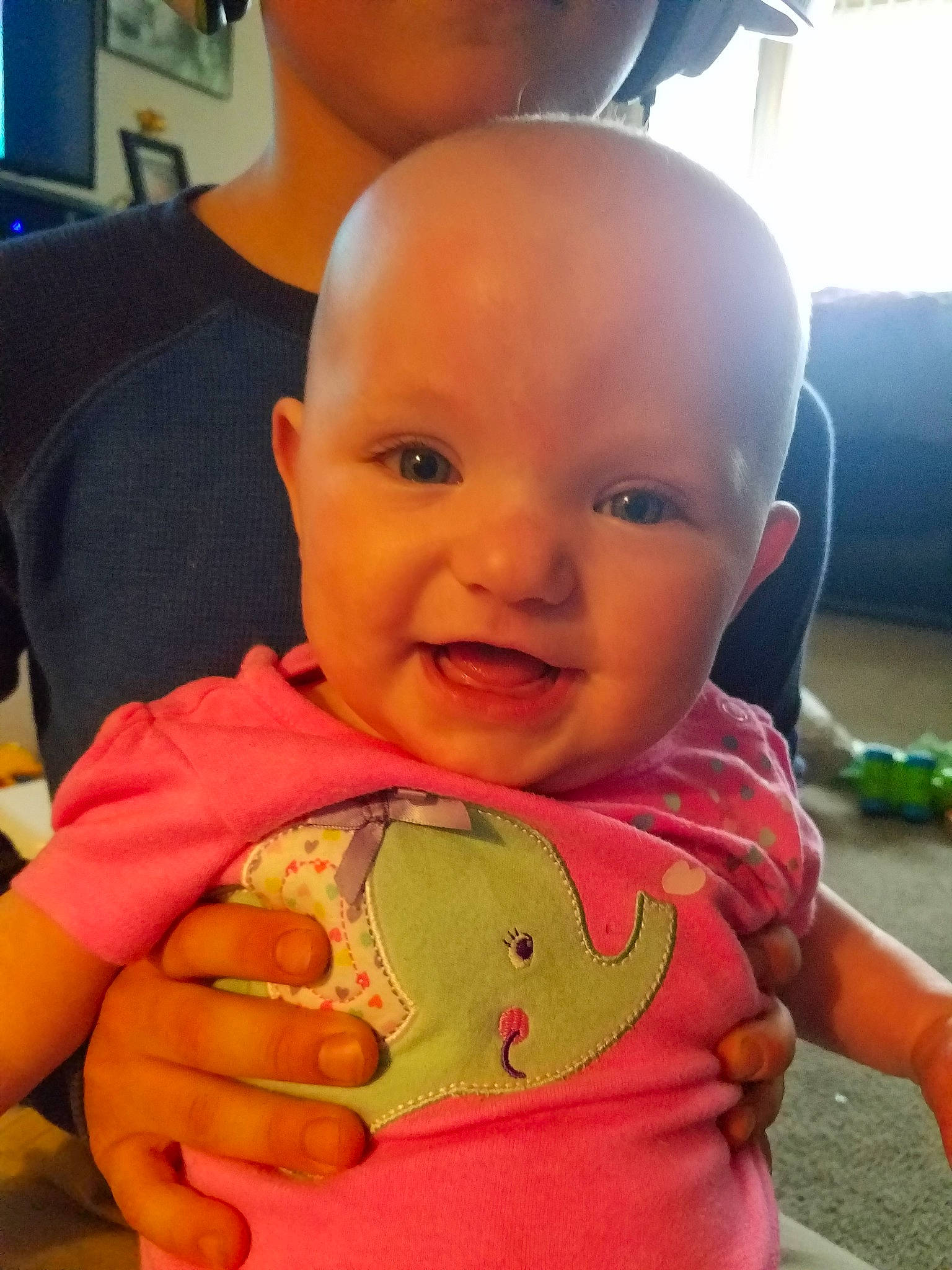 Maisie is registered to the contest to win money with this photo: abdomen, baby, cheek, child, ear, eye, face, finger, forehead, head, lip, mouth, neck, nose, person, play, skin, smile, thumb, toddler