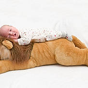 Enzo participe au concours pour gagner de l'argent avec cette photo : baby, infant, stuffed_animal, lion, pajamas, sleeping, soft, plush, cute, child, toy, cozy, lying_down, white_background, peaceful, resting, indoors, young_child, adorable, comfort