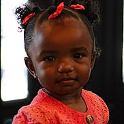 Harmony is registered to the contest to win money with this photo: toddler, child, girl, indoor, portrait, curly_hair, red_bows, coral_dress, button, face, expression, young, cute, person, childhood, fashion, hairstyle, skin_tone, looking_at_camera, soft_lighting