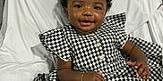 Harmony joined the competition — help win amazing prizes! baby, black_and_white, bows, bracelet, chair, child, clothing, curly_hair, cute, dress, fabric, footwear, happy, houndstooth, indoors, person, portrait, sitting, smiling, white_socks