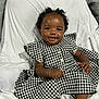 baby, black_and_white, bows, bracelet, chair, child, clothing, curly_hair, cute, dress, fabric, footwear, happy, houndstooth, indoors, person, portrait, sitting, smiling, white_socks