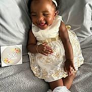 Harmony is registered to the contest to win money with this photo: accessory, baby, blanket, bracelet, celebration, child, cute, dress, fabric, footwear, happy, headband, indoors, infant, milestone_card, person, portrait, sitting, six_months, smiling