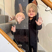 Gurbaaz is registered to the contest to win money with this photo: child, children, reflection, glass, staircase, turban, smile, family, indoor, person, footwear, black_clothing, hand, barefoot, wooden_railing, carpet, happy, posing, cute, playing