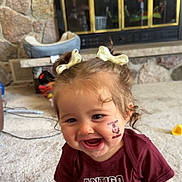 Kleo joined the competition — help win amazing prizes! bows, carpet, child, curly_hair, cute, drool, face, fireplace, happy, indoor, living_room, person, pigtails, shirt, smiling, stone_wall, temporary_tattoo, toddler, toys, young_child